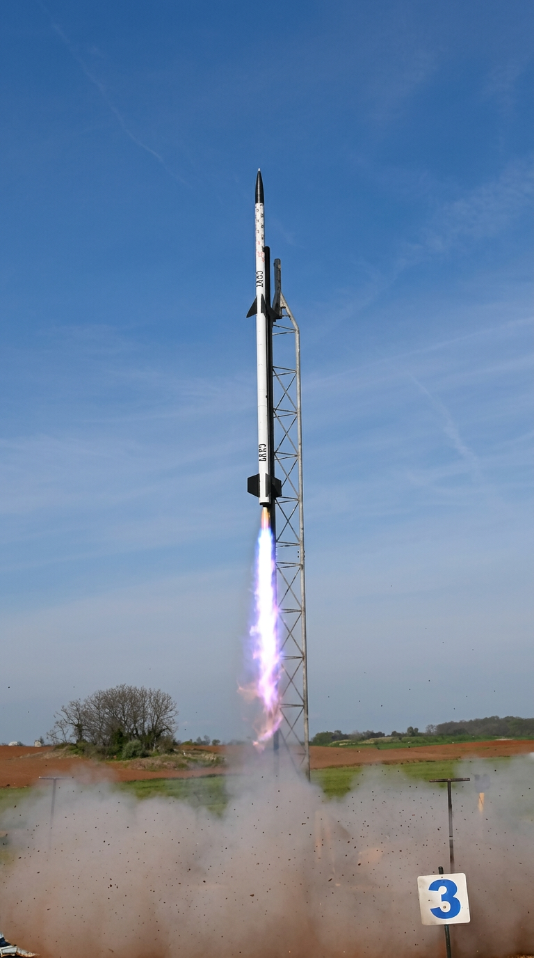 A Lightridge rocket launching into a bright blue sky with a violet exhaust plume